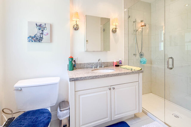 Bright bathroom with granite countertop, glass shower, and medicine cabinet. - 1249 Chartwell Place, West Vancouver