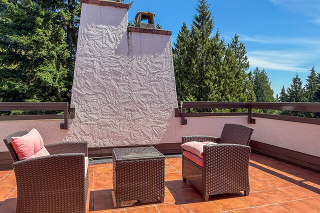 A sunny balcony with wicker chairs and a scenic tree view - 1249 Chartwell Place, West Vancouver