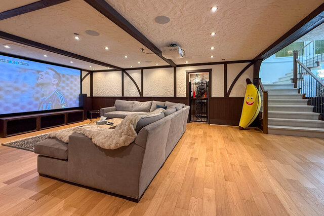 Spacious living room with a large screen, projector, and comfortable seating. - 1249 Chartwell Place, West Vancouver