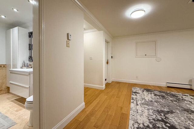 Well-lit living room with hardwood floors and adjacent bathroom. - 1249 Chartwell Place, West Vancouver