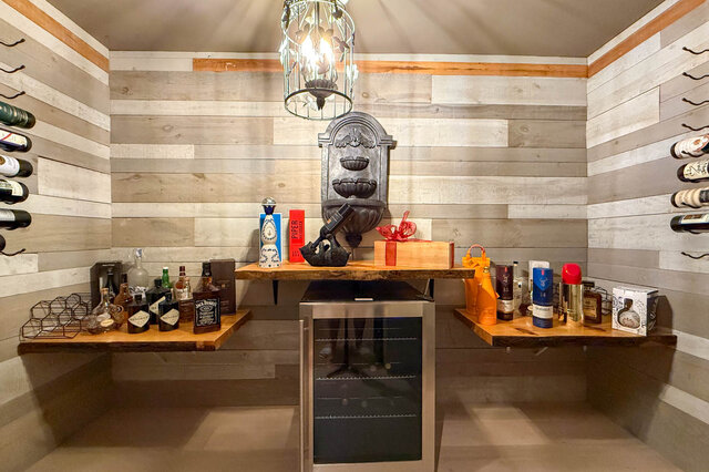 A stylish home bar with wooden shelves, wine storage, and a mini-fridge. - 1249 Chartwell Place, West Vancouver