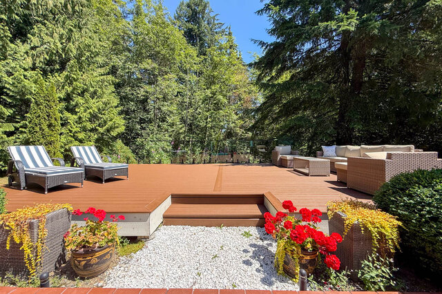 Sunny outdoor deck with lounge chairs, vibrant flowers, and lush greenery - 1249 Chartwell Place, West Vancouver