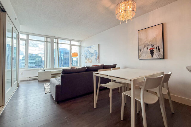 Bright living/dining space with city views through large windows and dark hardwood flooring. - 2113-610 Granville Street, Vancouver Downtown