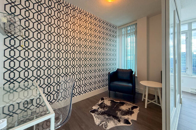 Living room with geometric wallpaper and city views through tall windows. - 2113-610 Granville Street, Vancouver Downtown