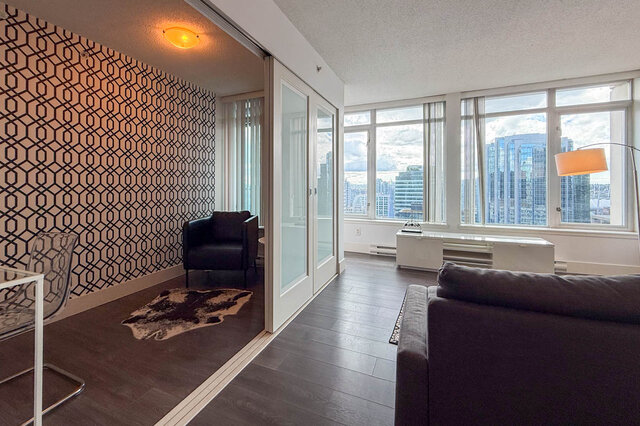 Living room with city view through large windows and dark hardwood flooring. - 2113-610 Granville Street, Vancouver Downtown