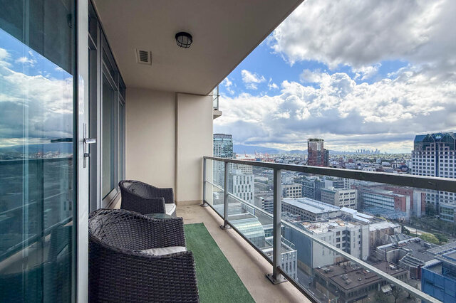 Balcony with wicker chairs and panoramic city view overlooking downtown Vancouver. - 2113-610 Granville Street, Vancouver Downtown