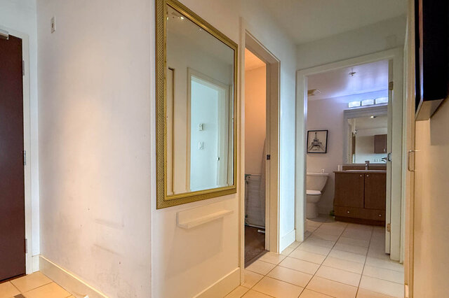 Hallway with gold-framed mirror and white tile flooring. - 2113-610 Granville Street, Vancouver Downtown