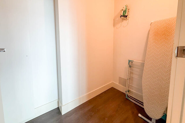Compact utility space with patterned ironing board and wall-mounted iron. - 2113-610 Granville Street, Vancouver Downtown