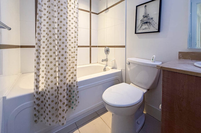 Modern bathroom with polka dot shower curtain and marble vanity countertop. - 2113-610 Granville Street, Vancouver Downtown