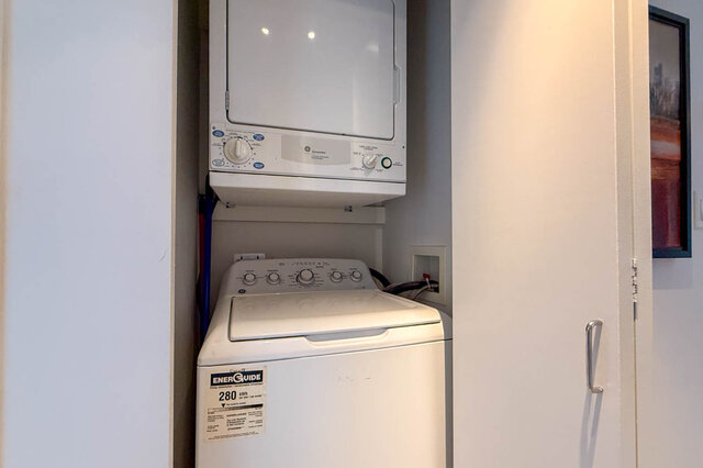 Compact laundry space with stacked white washer and dryer unit. - 2113-610 Granville Street, Vancouver Downtown