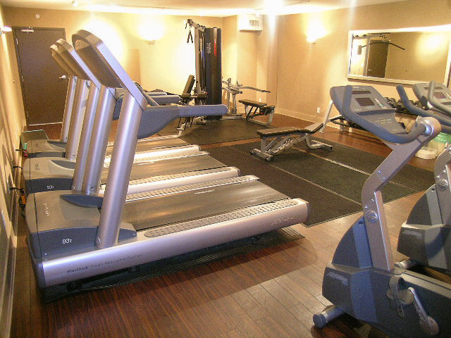 Well-equipped fitness center with treadmill rows and elliptical machines on hardwood floors. - 2113-610 Granville Street, Vancouver Downtown