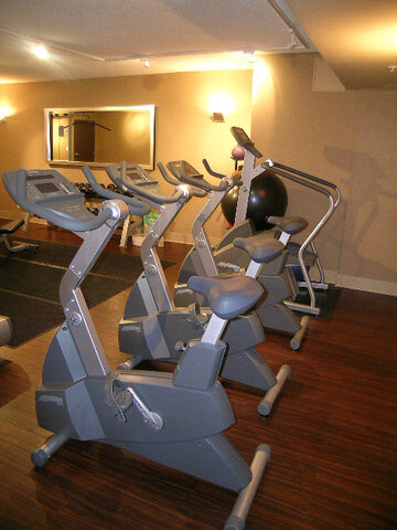 Furnished gym with stationary bikes and dark hardwood flooring. - 2113-610 Granville Street, Vancouver Downtown