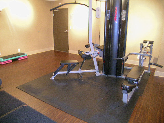 Well-equipped fitness room with leg press machine on polished hardwood flooring. - 2113-610 Granville Street, Vancouver Downtown