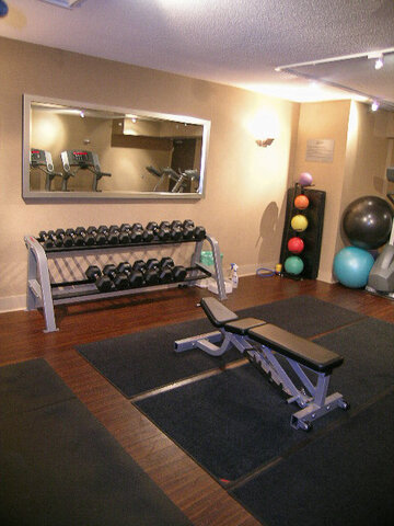 Well-equipped gym with dumbbell racks and colorful exercise balls on hardwood floors. - 2113-610 Granville Street, Vancouver Downtown