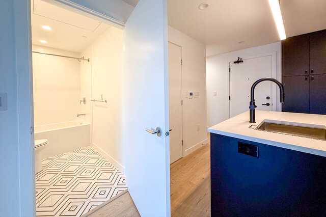 Bright kitchen with white countertop and geometric tile bathroom floor. - 204-1680 East 12th Avenue, Vancouver East Side