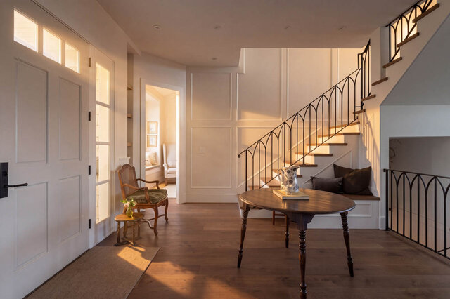Bright entrance hall with hardwood floors, wrought iron staircase, and small windows. - 1248 Kings Avenue, West Vancouver