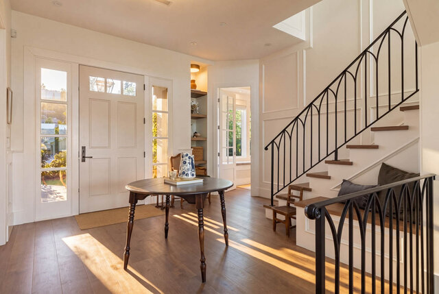 Bright living room with hardwood floors, French doors, and black iron staircase railing. - 1248 Kings Avenue, West Vancouver