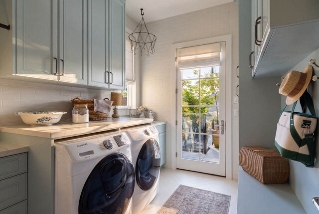 A bright laundry room with light blue cabinets, white brick walls, and small windows - 1248 Kings Avenue, West Vancouver