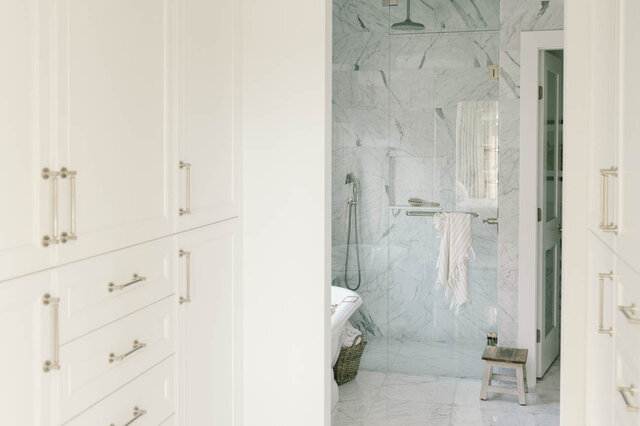 A bright bathroom with marble tile shower, white cabinetry, and small window. - 1248 Kings Avenue, West Vancouver