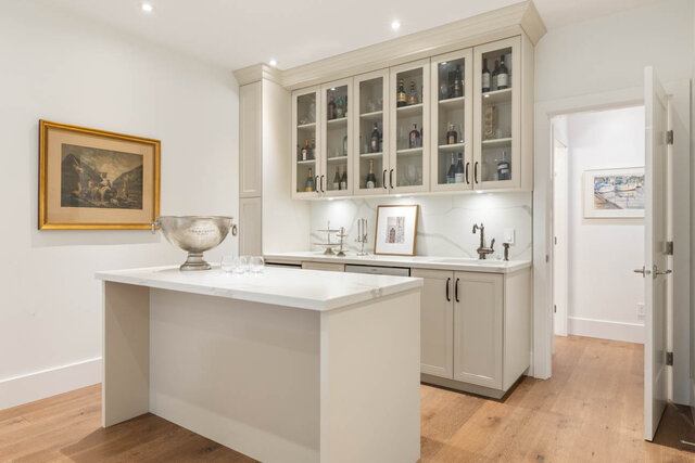 A bright, modern kitchen with white cabinetry, glass-front cabinets, and marble countertops - 1248 Kings Avenue, West Vancouver