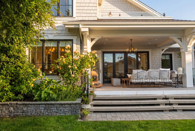 Sunny exterior shot of a modern home with covered porch, large windows, and landscaped garden. - 1248 Kings Avenue, West Vancouver