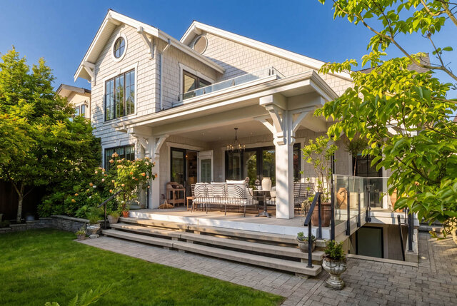 A bright exterior shot of a modern house with a covered balcony, large windows, and landscaped garden. - 1248 Kings Avenue, West Vancouver