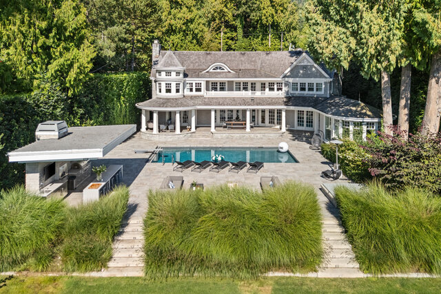 The building exterior features a large house, swimming pool, lounge chairs, columns on the porch, and landscaped greenery.