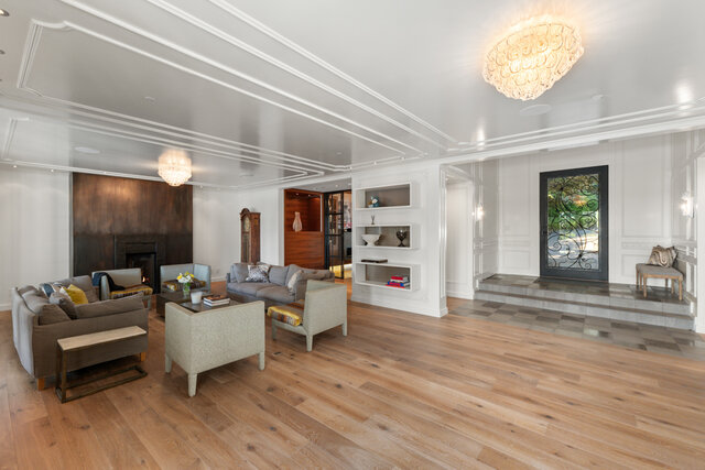 The living room contains sofas, a coffee table, a fireplace, built-in shelves, and chandeliers. - 2940 Mathers Avenue, West Vancouver