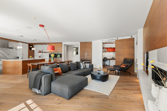 The living room features a gray sectional sofa, a black coffee table, a fireplace, and hardwood floors. - 2940 Mathers Avenue, West Vancouver