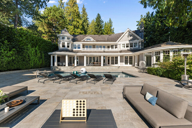 The pool area features a swimming pool, lounge chairs, a stone patio, and a large house with columns in the background.