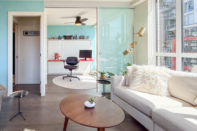 Living room with light blue accent wall and hardwood floors. - 505-189 Keefer Street, Vancouver Downtown
