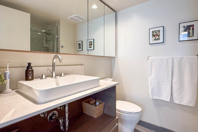 Bathroom with white vessel sink and large mirror above light countertop. - 505-189 Keefer Street, Vancouver Downtown