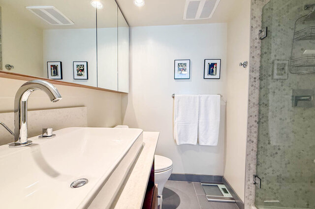 Modern bathroom with white countertop and glass shower enclosure. - 505-189 Keefer Street, Vancouver Downtown