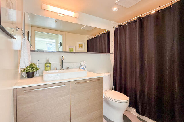 Bathroom with light wood vanity and dark shower curtain. - 505-189 Keefer Street, Vancouver Downtown