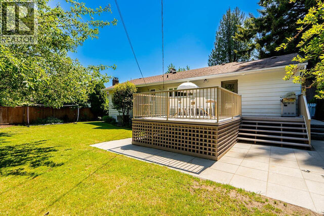The building exterior shows a wooden deck, grassy lawn, fence, and mature trees. - 2784 Crescentview Drive, North Vancouver