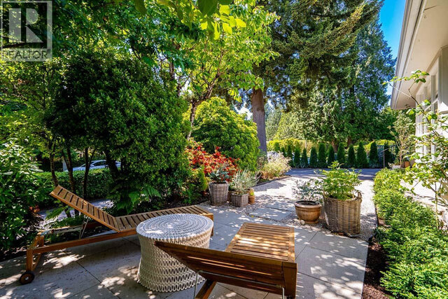 The balcony features outdoor seating, potted plants, and mature trees on a paved patio. - 2784 Crescentview Drive, North Vancouver