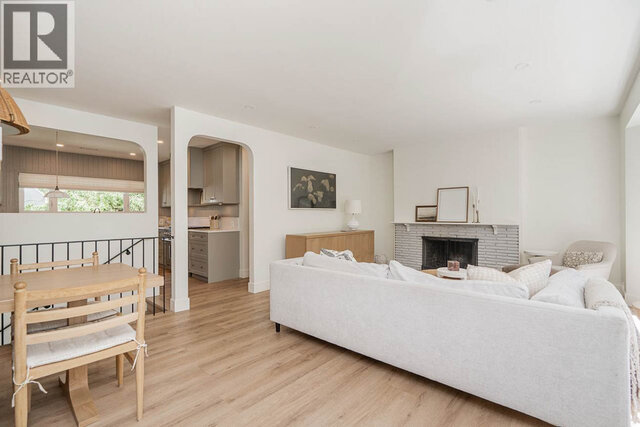 The living room contains a large sofa, a stone fireplace, and hardwood floors. - 2784 Crescentview Drive, North Vancouver