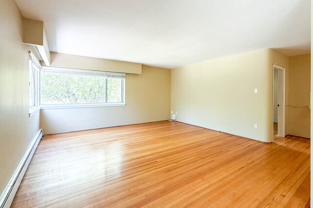 This is a bedroom with hardwood floors and a window. - 102-461 16th West street, North Vancouver