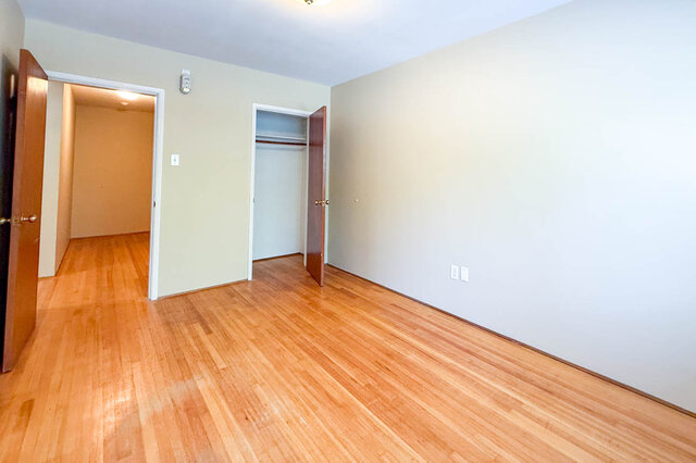 This is a bedroom with hardwood floors and a closet. - 102-461 16th West street, North Vancouver
