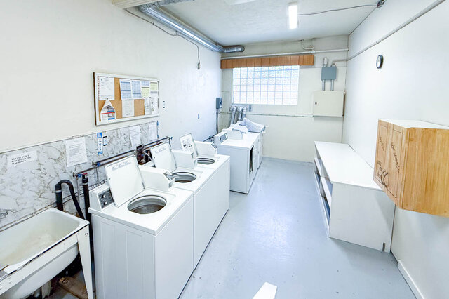 laundry room with washing machines, a bulletin board, a small window, and a sink - 102-461 16th West street, North Vancouver