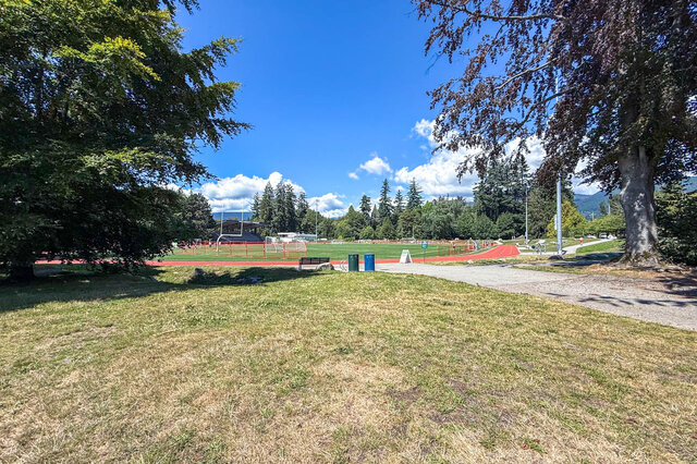 The view shows a running track, soccer field, trees, and a pathway. - 102-461 16th West street, North Vancouver