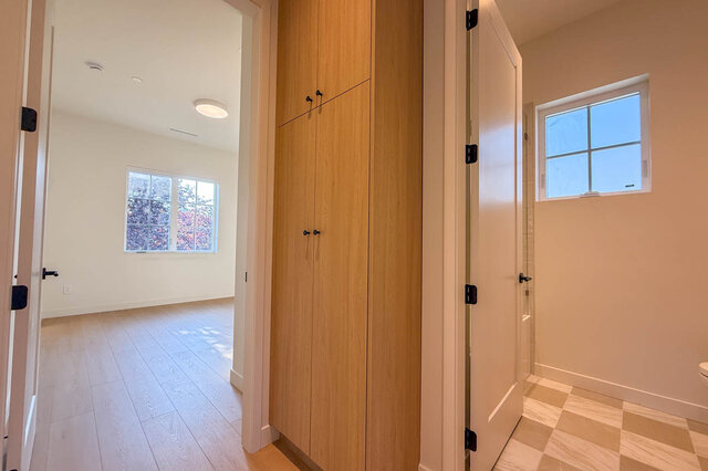 Hallway with tall wooden storage cabinet and light hardwood floors. - 3038 Vine Street, Vancouver West Side