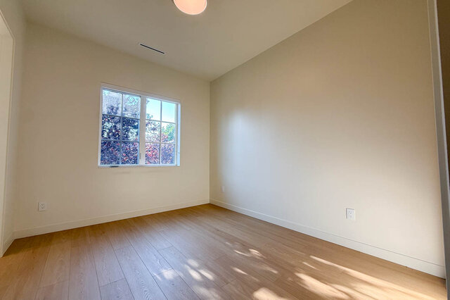 Bright bedroom with hardwood floors and natural light through window. - 3038 Vine Street, Vancouver West Side