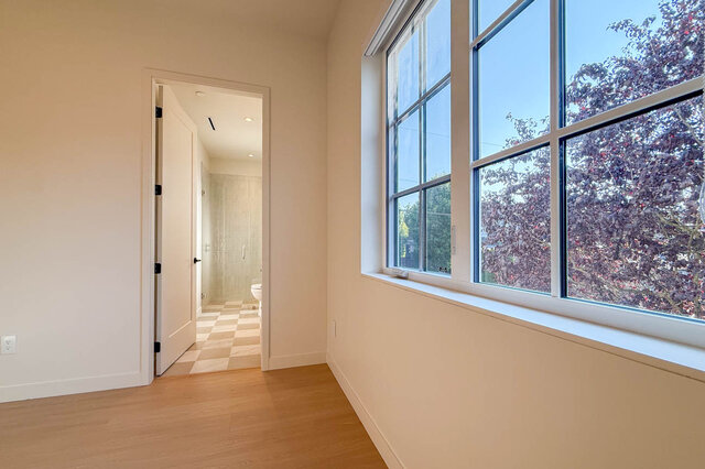 Light-filled hallway with hardwood floors and large windows showing tree views. - 3038 Vine Street, Vancouver West Side