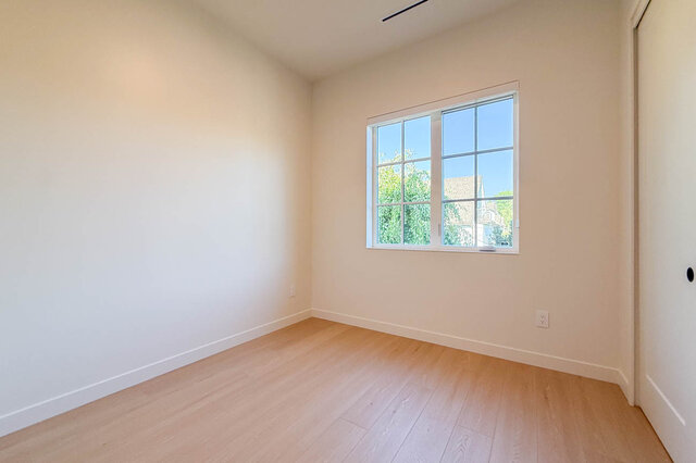 Spacious bedroom with hardwood floors and a bright window view of greenery. - 3038 Vine Street, Vancouver West Side
