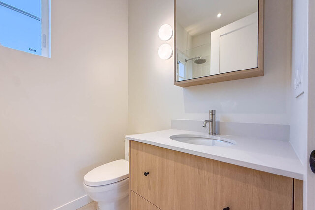Modern bathroom with light wood vanity and white quartz countertops. - 3038 Vine Street, Vancouver West Side