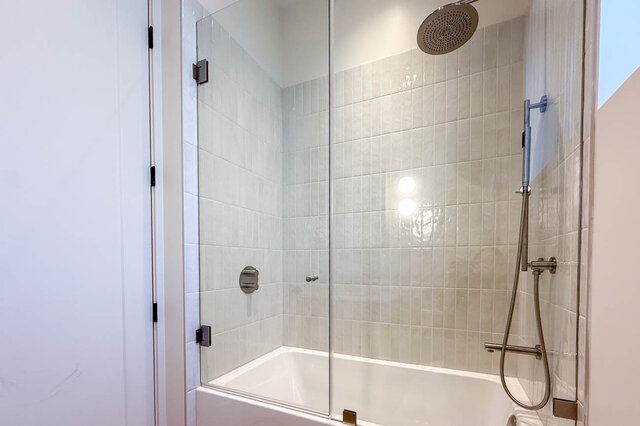 Bathroom with glass-enclosed shower and light gray tile walls. - 3038 Vine Street, Vancouver West Side