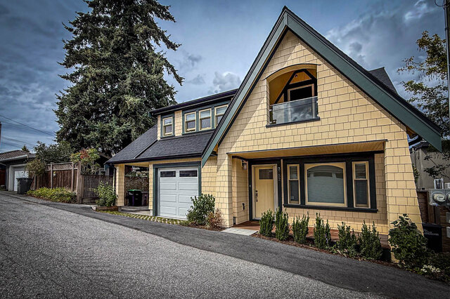 Yellow brick laneway house exterior with dark green trim, gabled roof, and attached garage. - 3752 West 23rd Avenue, Vancouver West Side
