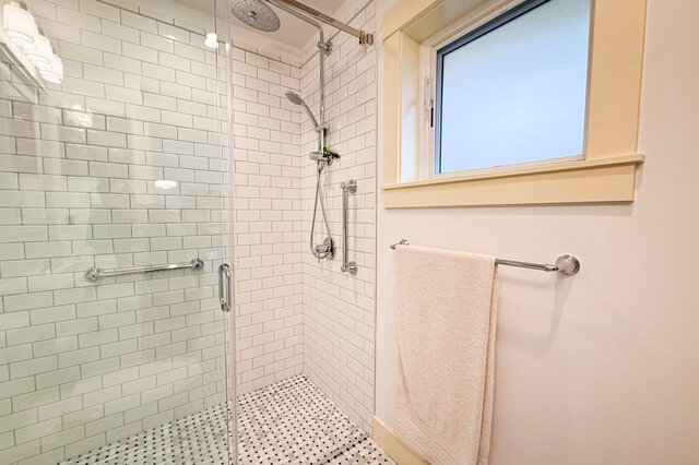 Bathroom featuring white subway tile, a glass shower enclosure, and chrome fixtures. - 3752 West 23rd Avenue, Vancouver West Side