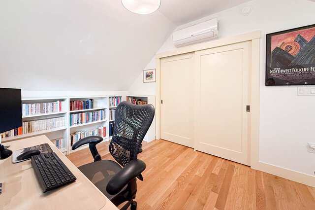 Home office with hardwood floors, built-in bookshelves, and a black mesh desk chair. - 3752 West 23rd Avenue, Vancouver West Side